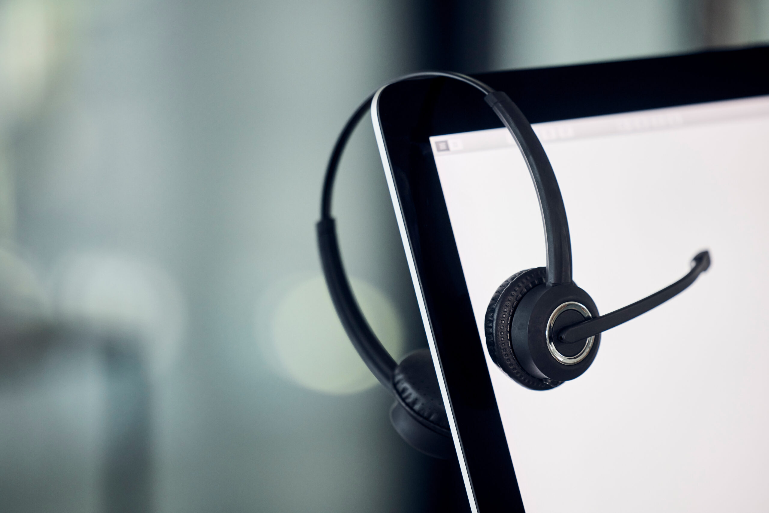 Call center, laptop screen and headset Laptop in modern office for customer service, contact us and virtual information technology support